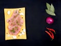 Sliced pieces of meat turkey game filet on a wooden cutting board, garlic, salt, fennel, allspice, green laurel leaf, red chili Royalty Free Stock Photo