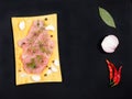 Sliced pieces of meat turkey game filet on a wooden cutting board, garlic, salt, fennel, allspice, green laurel leaf, red chili Royalty Free Stock Photo