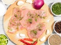 Sliced pieces of meat turkey game filet on a wooden cutting board, garlic, salt, fennel, allspice, red chili pepper, green onion, Royalty Free Stock Photo