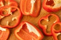 Sliced pieces, parts, lobes of sweet pepper, red, scattered on a wooden board Royalty Free Stock Photo