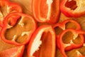 Sliced pieces, parts, lobes of sweet pepper, red, scattered on a wooden board Royalty Free Stock Photo