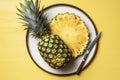 Sliced Pineapple on plate with tropical palm leaves. Bromelain whole pineapple summer fruit halves pineapple on black dark Royalty Free Stock Photo