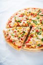 Sliced pizza with mozzarella cheese, chicken, sweet corn, sweet pepper and parsley on white background close up Royalty Free Stock Photo