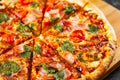 Sliced Pizza with Mozzarella cheese, Ham, Tomatoes, pepper, Spices and Fresh Basil pesto sauce. Royalty Free Stock Photo