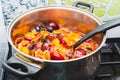 Sliced plum berries are boiled in a large saucepan. Making fruit jam, preserving and preparing for the winter Royalty Free Stock Photo