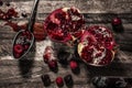 Sliced pomegranate on rustic wooden background.