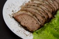 Sliced pork meat with lettuce leaves on a plate Royalty Free Stock Photo