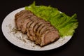 Sliced pork meat with lettuce leaves on a plate Royalty Free Stock Photo