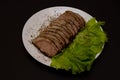 Sliced pork meat with lettuce leaves on a plate Royalty Free Stock Photo