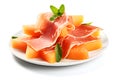 Sliced Prosciutto ham with melon cantaloupe on white plate on white background. Italian appetizers. Concept of Italian food. Royalty Free Stock Photo