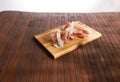 sliced prosciutto on a wooden board. pork ham on a light background. composition meat delicacy with olives and bread.