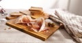 sliced prosciutto on a wooden board. pork ham on a light background. composition meat delicacy with olives and bread.