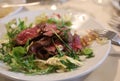 sliced rare beef served on a plate of rocket at the restaurant Royalty Free Stock Photo