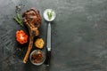 Sliced rare grilled or barbecued tomahawk beef steak on a griddle with fresh rosemary and tomato in a close up view. Royalty Free Stock Photo