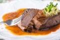 Sliced rare grilled Beef steak Ribeye with sauce on white plate. Selective focus