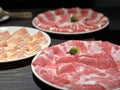 Sliced raw beef, lamb, pork served on three white plates for hot pot also known as Shabu Shabu or Sukiyaki. Chinese food Royalty Free Stock Photo