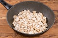 Sliced raw button mushrooms in frying pan on rustic table Royalty Free Stock Photo