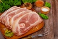 Sliced raw pork shoulder with spices on wooden board Royalty Free Stock Photo