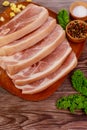Sliced raw pork shoulder with spices on wooden board Royalty Free Stock Photo