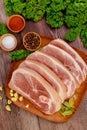 Sliced raw pork shoulder with spices on wooden board Royalty Free Stock Photo