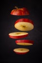 sliced red apple free flying on a dark soft background.  artistic moody close-up photo. selective focus Royalty Free Stock Photo