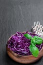 Sliced red cabbage in wooden bowl on black stone background Royalty Free Stock Photo