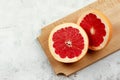 Sliced red grapefruit on a wooden cutting board on a light gray background Royalty Free Stock Photo