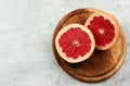 Sliced red grapefruit on a wooden cutting board on a light gray background Royalty Free Stock Photo