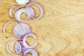 Sliced red onion rings on wooden background top view with space wor text