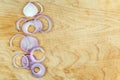 Sliced red onion rings on wooden background top view with space wor text