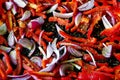 Sliced red pepper and red onions in roasting dish