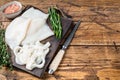 Sliced rings Raw Calamari or Squid on a wooden board with rosemary. wooden background. Top view. Copy space Royalty Free Stock Photo