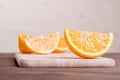 Sliced ripe appetizing delicious orange on cutting board brown t Royalty Free Stock Photo