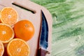 sliced ripe appetizing orange on a cutting board on a green table Royalty Free Stock Photo