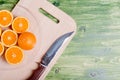 sliced ripe appetizing orange on a cutting board on a green table Royalty Free Stock Photo