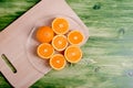 sliced ripe appetizing orange on a cutting board on a green table Royalty Free Stock Photo