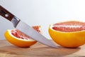 Sliced ripe juicy Sicilian Blood oranges and knife on wooden board