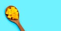 Sliced ripe mango cubes on wooden spoon on blue background Royalty Free Stock Photo