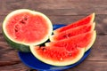 Sliced ripe red watermelon on a blue plate on a wooden table Royalty Free Stock Photo