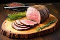 sliced roast beef on a circular wooden chopping block