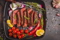 Sliced roast beef in a frying pan grill with spices and vegetables, top view, copy space. Royalty Free Stock Photo