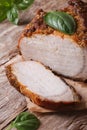 Sliced roast pork tenderloin and basil close-up vertical