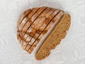 Sliced round loaf of rye bread with an appetizing crispy brown crust on a gray linen tablecloth. Tasty, usefull and nutritious. Royalty Free Stock Photo