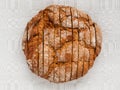 Sliced round loaf of rye bread with an appetizing crispy brown crust on a gray linen tablecloth. Tasty, usefull and nutritious.