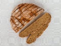 Sliced round loaf of rye bread with an appetizing crispy brown crust on a gray linen tablecloth. Tasty, usefull and nutritious. Royalty Free Stock Photo
