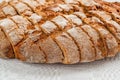 Sliced round loaf of rye bread with an appetizing crispy brown crust on a gray linen tablecloth. Tasty, usefull and nutritious. Royalty Free Stock Photo