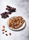 Sliced rusk fruit bread on a plate with red grapes, rosins and almond nuts. Royalty Free Stock Photo