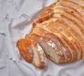 A sliced rustic bread on white napkin background