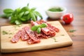 sliced salami on a wooden board with basil leaves Royalty Free Stock Photo