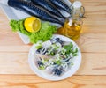 Sliced salted Atlantic mackerel against of raw fish carcasses